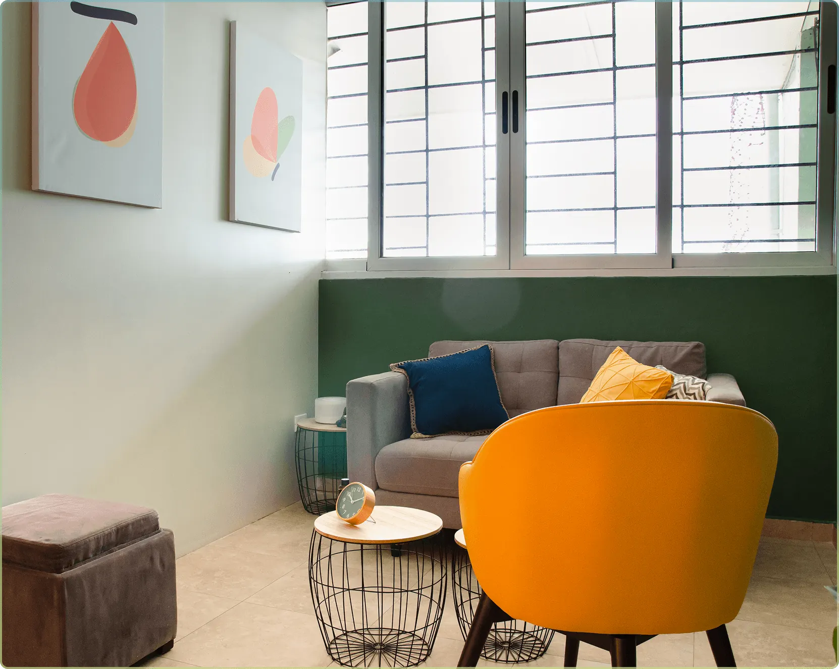 Sala de terapia de Farfalle con sofá, silla amarilla y paredes de colores